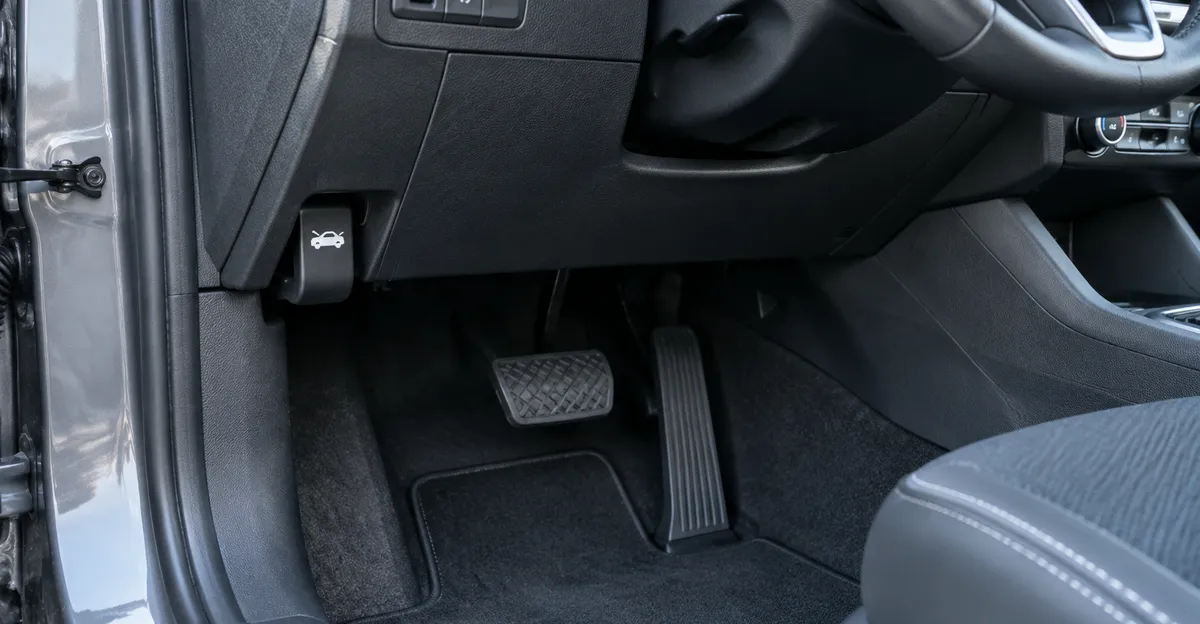 Driver seat view of a hood release lever under the left side of the dashboard