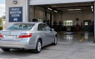Sedan waiting at a U.S. vehicle inspection station bay with an open service door