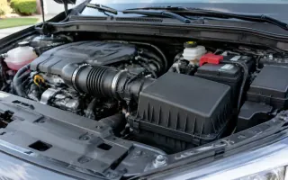 Open engine bay with a black plastic airbox and intake tube on a passenger car