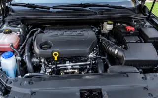 Open engine bay with translucent fluid reservoirs and a bright oil dipstick handle