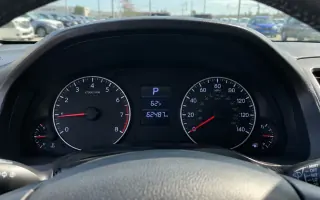 Dashboard odometer and instrument cluster in a used sedan on a lot