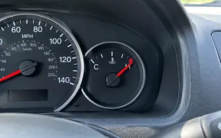 Dashboard temperature gauge climbing toward the red zone on a US vehicle